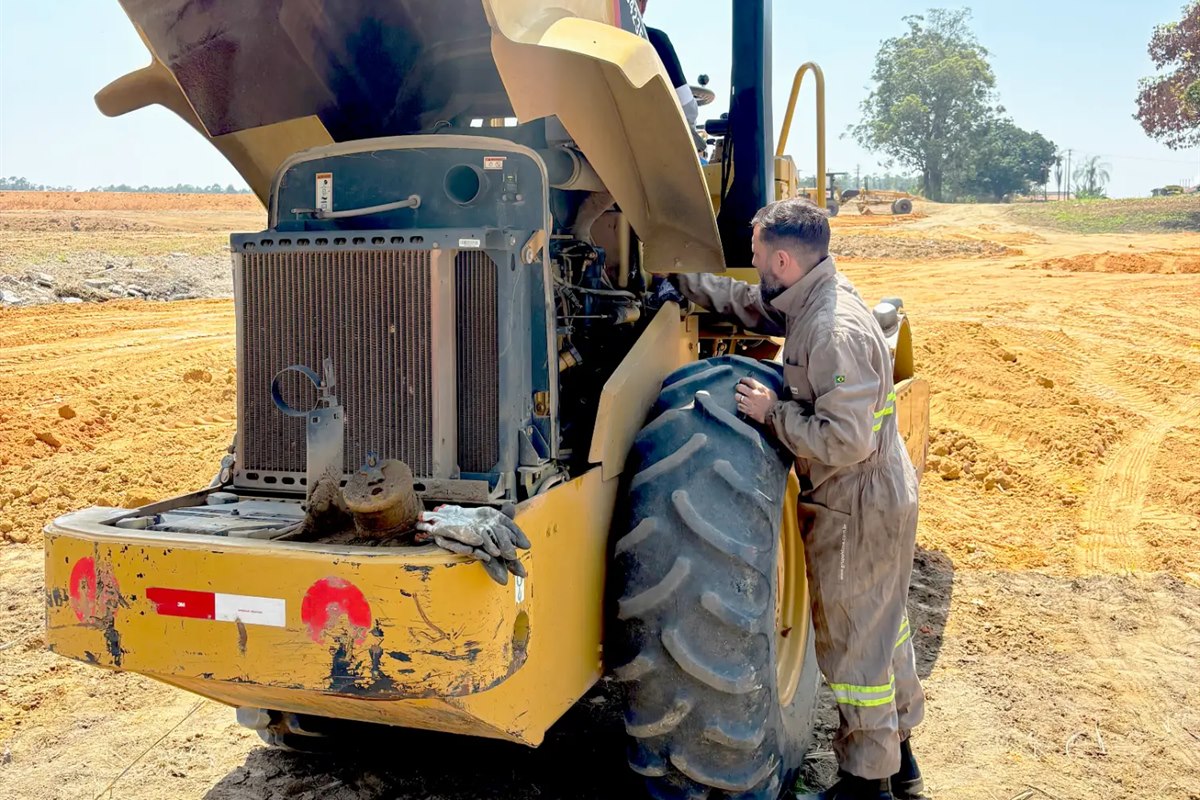 Mecânico da Hloc fazendo a manutenção de um rolo compactador na obra